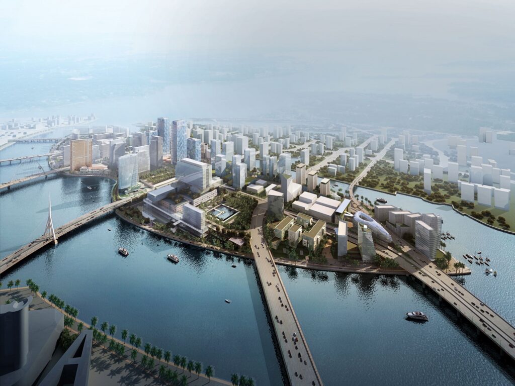 Modern waterfront skyline of Al Maryah Island with high-rise buildings, bridges, and blue sky reflected in calm water.