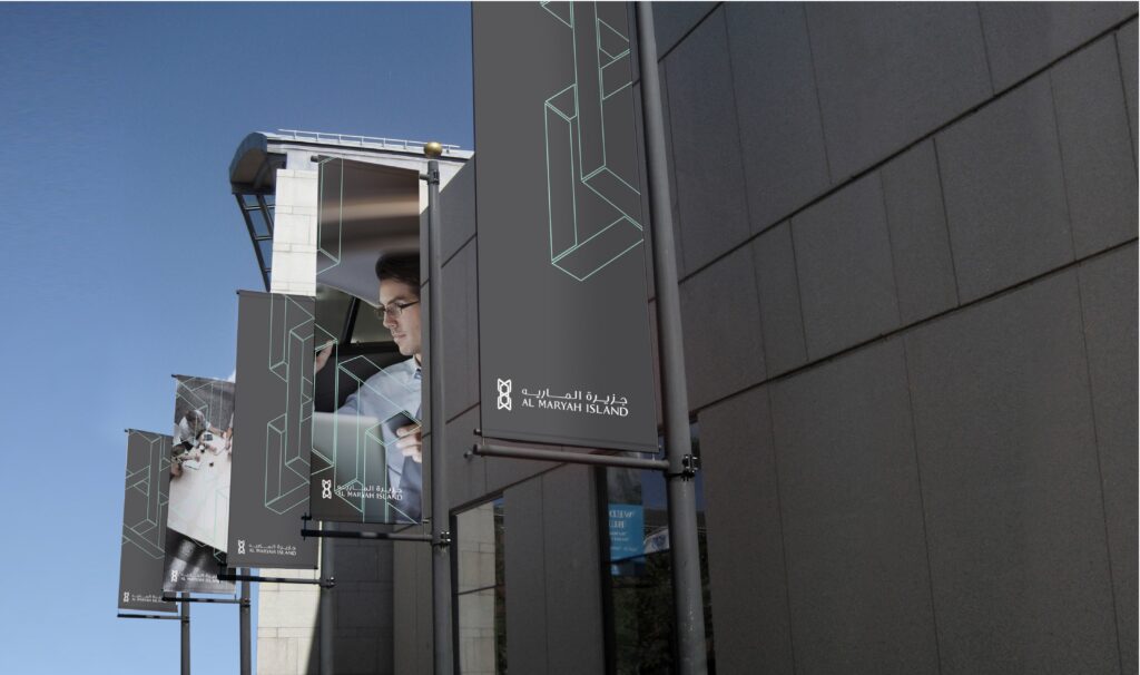 Contemporary glass building facade with an external elevator and geometric architectural detailing.