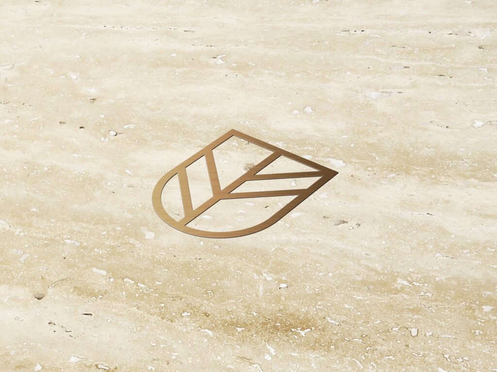 Minimalist leaf-shaped logo in gold set against a textured natural stone background.