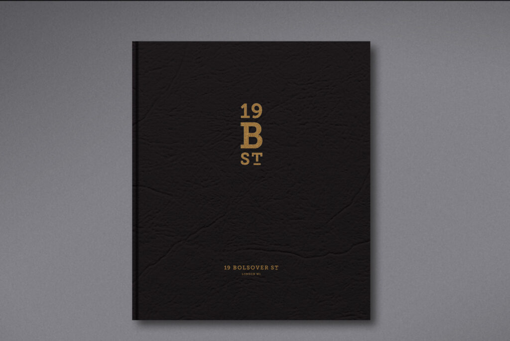 Minimalist black brochure cover with gold embossed lettering reading “19 B ST” and “19 Bolsover St London W1.”
