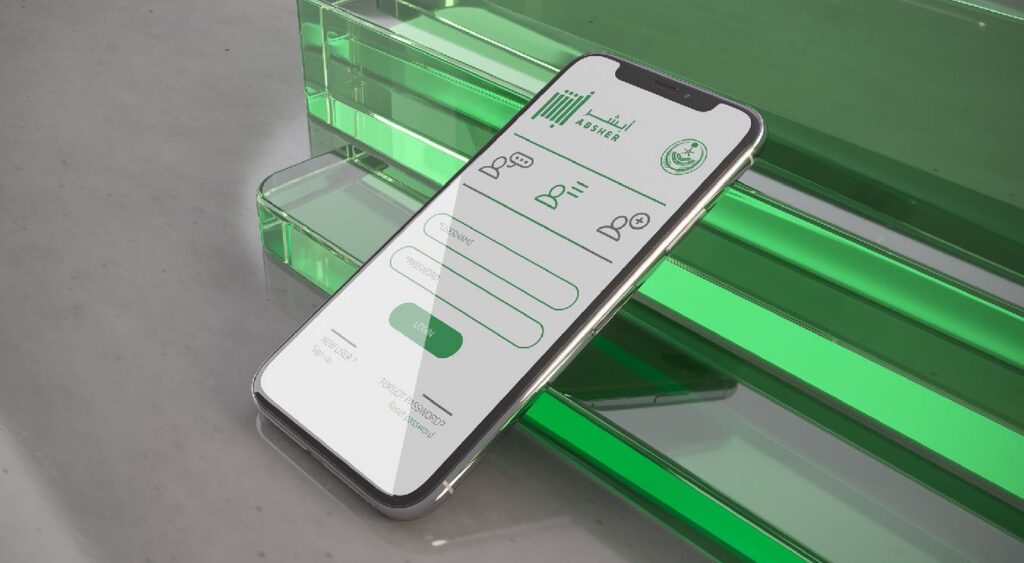 Smartphone displaying the Absher app interface placed on a glossy green surface with soft lighting reflections.