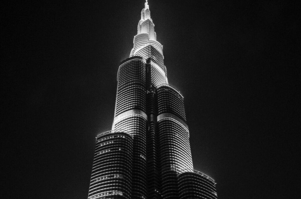 The Burj Khalifa skyscraper towering over Dubai’s skyline, a sleek glass-and-steel structure rising into the sky, surrounded by the city’s modern architecture.